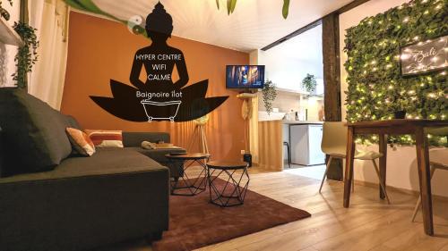 ein Wohnzimmer mit einem Sofa und einem Tisch sowie eine Küche in der Unterkunft Le Petit Bali in Sélestat