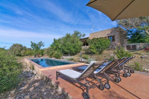 a group of chairs sitting next to a swimming pool at Font in Artá