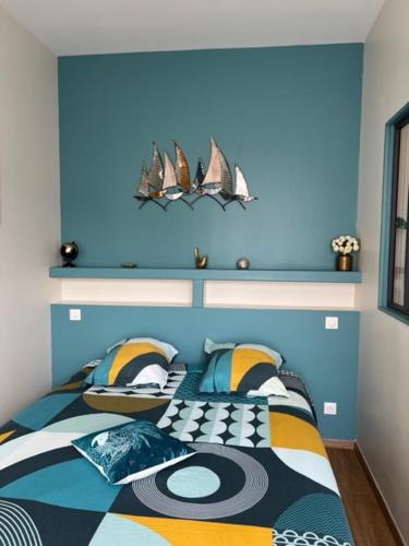 a bedroom with a bed with a blue head board at Gite du Port in Dieppe