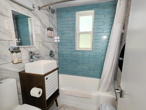 a bathroom with a tub and a sink and a toilet at Tahitian Beach Resort in St Pete Beach