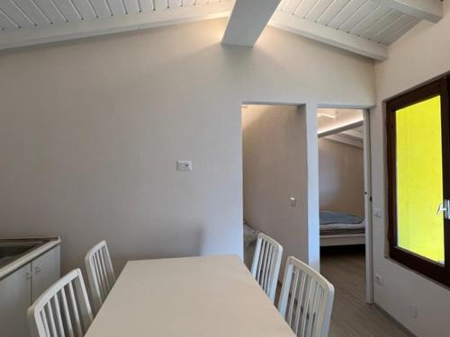 a white table and chairs in a kitchen with a window at Lakeview Cannobio Camping & Resort in Cannobio