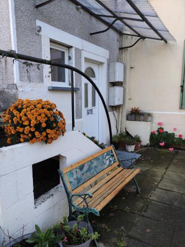 a wooden bench in front of a building with a flower box at Gite Les Eylauds in Pionsat