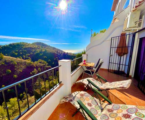 a balcony with chairs and a view of the mountains at Apartamentos Axarquia , Frigiliana, terraza privada con vistas a la montaña rio y al mar in Frigiliana