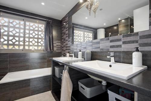 a bathroom with two sinks and a tub at Casa Helieta in Puerto del Rosario