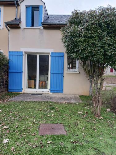 a house with blue doors and a yard at T3 la savane saint Geniez d'olt 2 piscines chauffées dans une charmante résidence de vacances in Saint-Geniez-dʼOlt