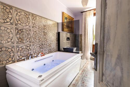 a bathroom with a large tub in a room at Palazzo Previtera in Linguaglossa