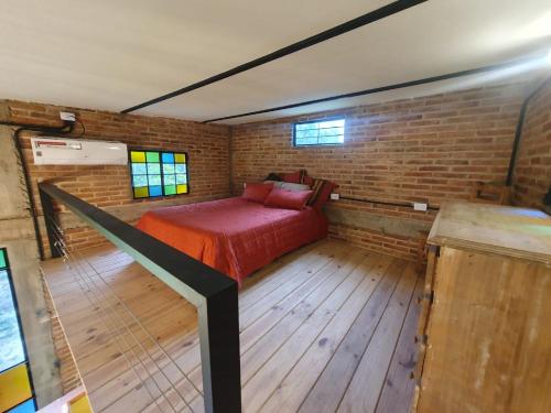 1 dormitorio con 1 cama en una pared de ladrillo en Loft El Taller - Rústico, elegante, acogedor en Yerba Buena