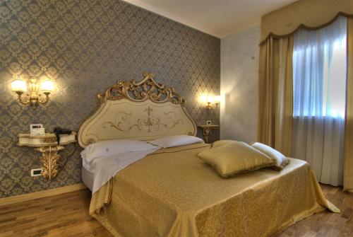 a bedroom with a large bed with a gold headboard at Villa Tuscolana in Frascati