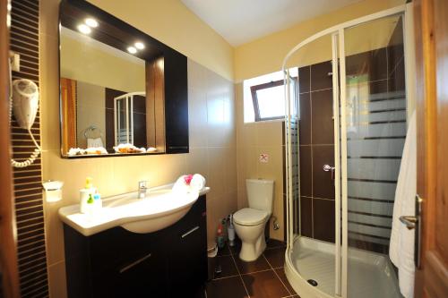 a bathroom with a sink and a shower and a toilet at Villa Casa Bianca Orange Apartment in Gaios