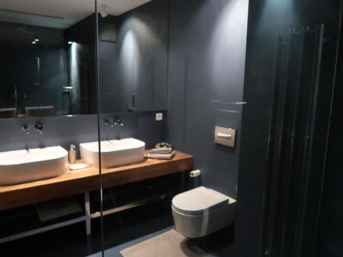 uma casa de banho com 2 lavatórios, um WC e um espelho. em Michal apartment 125m2 city centre em Praga