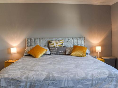 a bedroom with a large bed with two lamps at Helens View in Torpoint