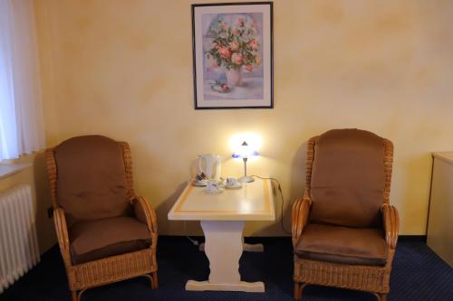 a room with two chairs and a table with a lamp at Haus Hubertus in Bad Peterstal-Griesbach