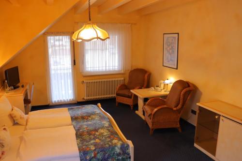 a bedroom with a bed and a table and chairs at Haus Hubertus in Bad Peterstal-Griesbach