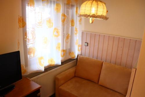 a living room with a couch and a window at Haus Hubertus in Bad Peterstal-Griesbach