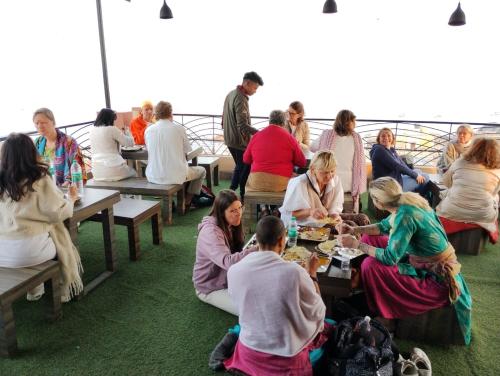 un grupo de personas sentadas en mesas en un crucero en KS PAYING GUEST HOUSE en Varanasi