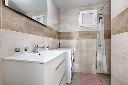 uma casa de banho com um lavatório branco e um espelho. em Casa Aliana em Puerto del Rosario