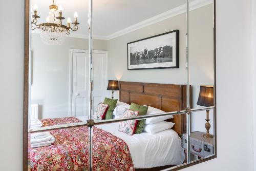 a bedroom with a bed with a mirror at Cannich Cottage at Parbroath Farm in Cupar