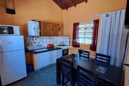 a kitchen with a table and a white refrigerator at Departamentos Pablos En Villa Gesell in Villa Gesell