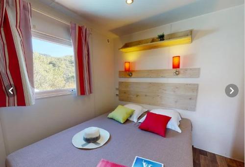 ein Schlafzimmer mit einem Bett mit Hut darauf in der Unterkunft Campasun Camping de l'Aigle in Aiguines