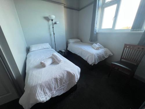 a room with two beds and a window at Links Lets Room Only in Seahouses