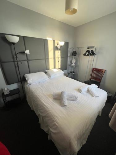 1 dormitorio con 1 cama blanca grande y toallas. en Links Lets Room Only, en Seahouses