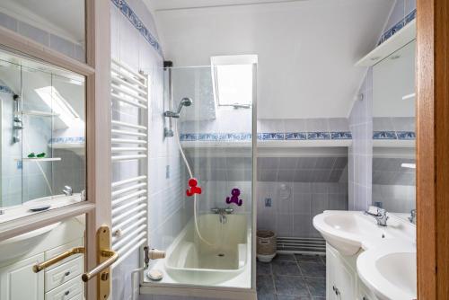 y baño con ducha, bañera y lavamanos. en Joli appartement moderne, pour 4, a Benodet, en Bénodet