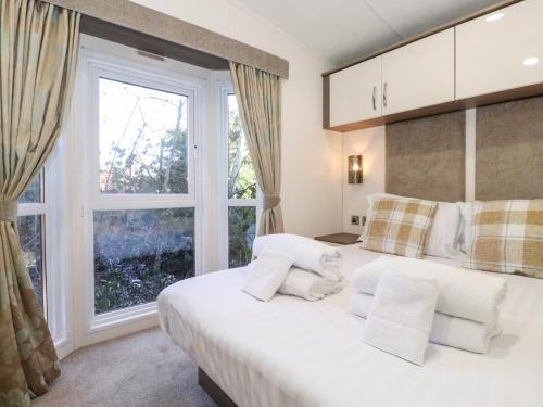 a bedroom with a large white bed and a window at Toucana in Morpeth