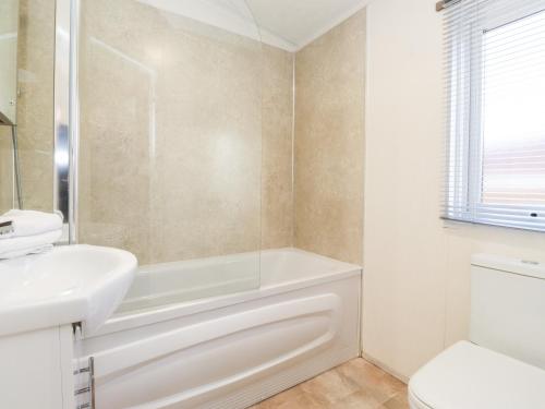 a white bathroom with a tub and a sink at Toucana in Morpeth