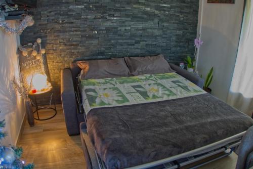 łóżko w pokoju z ceglaną ścianą w obiekcie Ka Hema w mieście Saint-Joseph