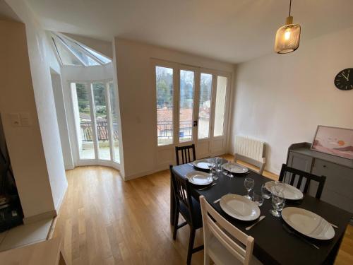 una sala da pranzo con tavolo e sedie neri di LE PERCHOIR-POITIERS-LaConciergerie a Poitiers