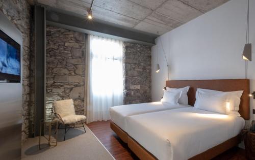 a bedroom with a large bed and a window at Hotel Cajú in Funchal