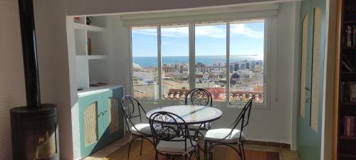 a dining room with a table and chairs and a window at Casa Lucia the most beautiful views sea and city in Alicante