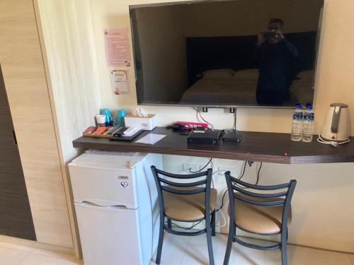 a man taking a picture of a desk with two chairs at Hermes B&B in Neipu