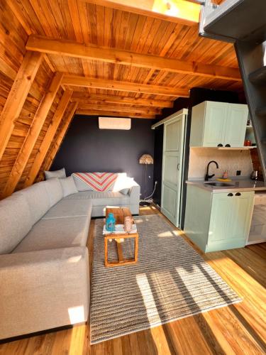 ein Wohnzimmer mit einem Sofa und einem Tisch in der Unterkunft Byelka Bungalov Ayvalık in Ayvalık