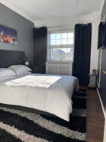 Un dormitorio con una gran cama blanca y una ventana en Thembile House, en Thornaby on Tees