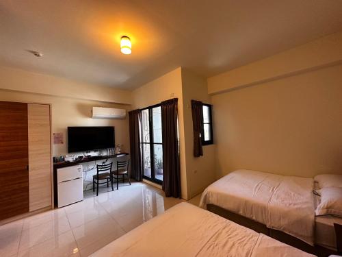 內埔鄉的住宿－愛瑪仕民宿，一间带两张床的卧室和一间带书桌的厨房