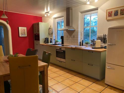 a kitchen with white appliances and a wooden table and a tableablish at Landhaus Galke in Hude