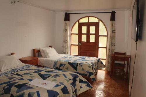 Habitación con 2 camas y puerta abierta en MESONERO en Ayacucho