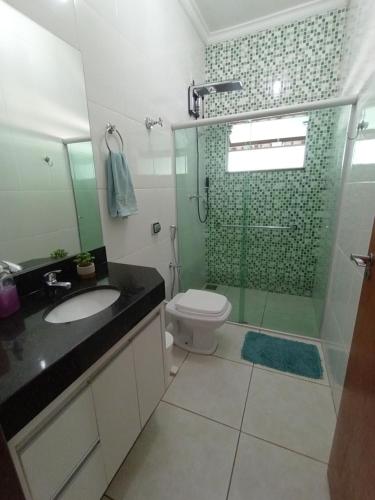 a bathroom with a toilet and a glass shower at Casa Temporada BV Capitolio in Capitólio