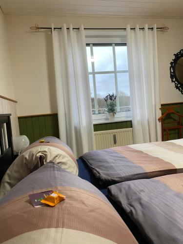 two beds in a room with a window at Landhaus Galke in Hude