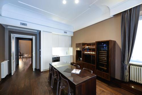 cocina con mesa y sillas en una habitación en The Babuino - Luxury serviced apartment, en Roma