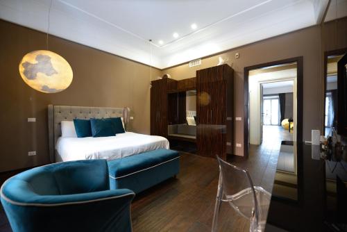 sypialnia z łóżkiem i niebieskim krzesłem w obiekcie The Babuino - Luxury serviced apartment w Rzymie