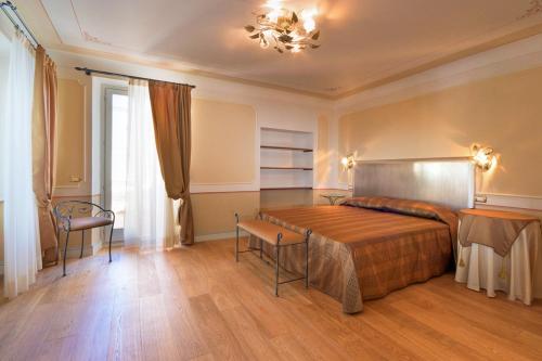 a bedroom with a bed and a table and a chair at Il Vicolo Relais in Sirolo
