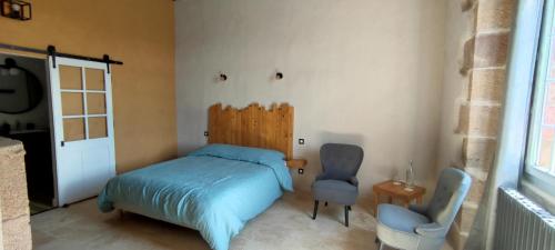 um quarto com uma cama, uma cadeira e uma janela em Domaine du Parc 
