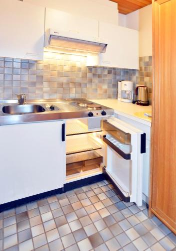 a kitchen with white cabinets and a sink in it at Appartements Kirchmair in Seefeld in Tirol