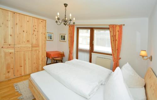 a bedroom with a white bed and a window at Appartements Kirchmair in Seefeld in Tirol