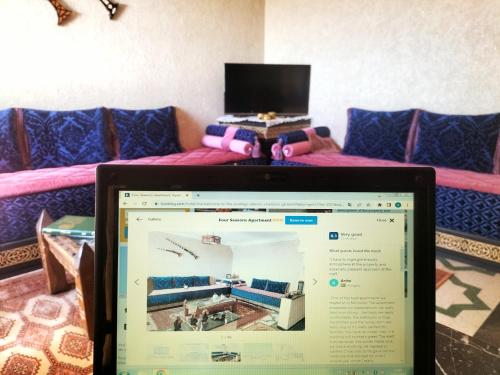 a laptop computer in a room with a bed at Four Seasons Apartment in Agadir