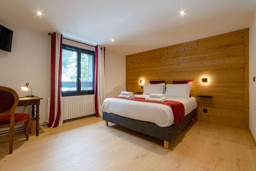 a bedroom with a large bed with a wooden wall at Hôtel Restaurant Le Madame in La Ferrière