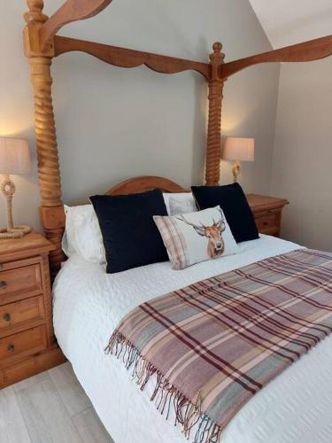 una camera con un grande letto con testiera in legno di Wildthorn Cottage a Moyad