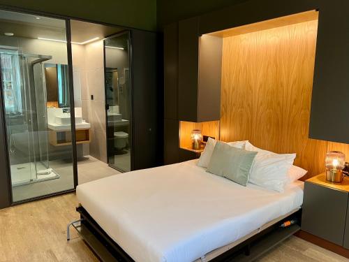a bedroom with a large bed and a bathroom at Oca Ribeira do Porto AT in Porto